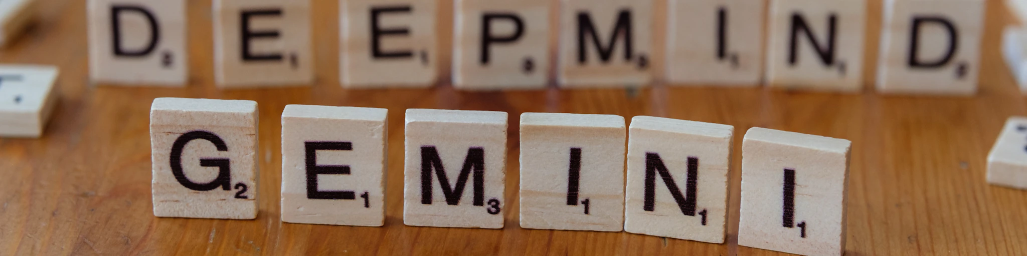 A wooden table topped with scrabble tiles spelling out the words deep mind,