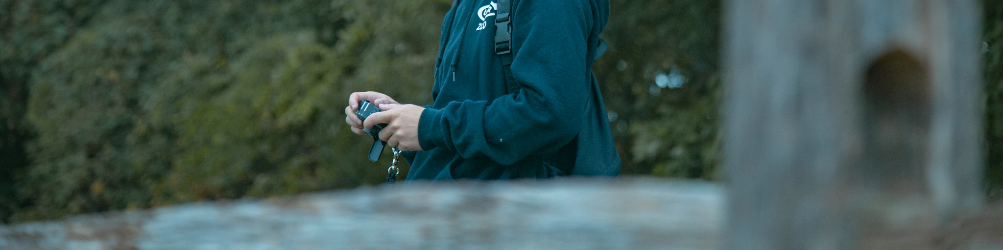 man holds camera near bridge