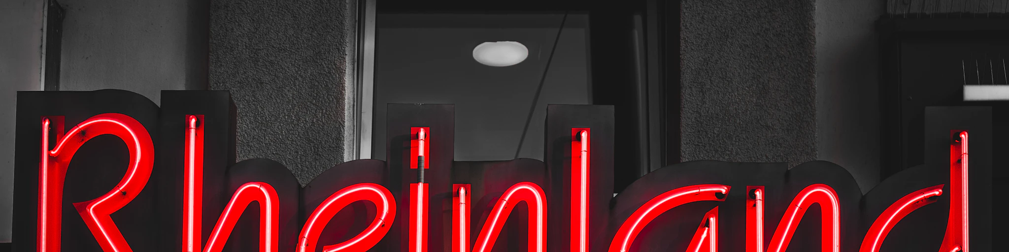 a red neon sign that reads rheineinland