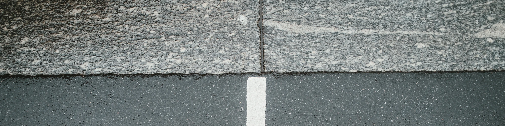 two white arrows pointing in opposite directions on asphalt