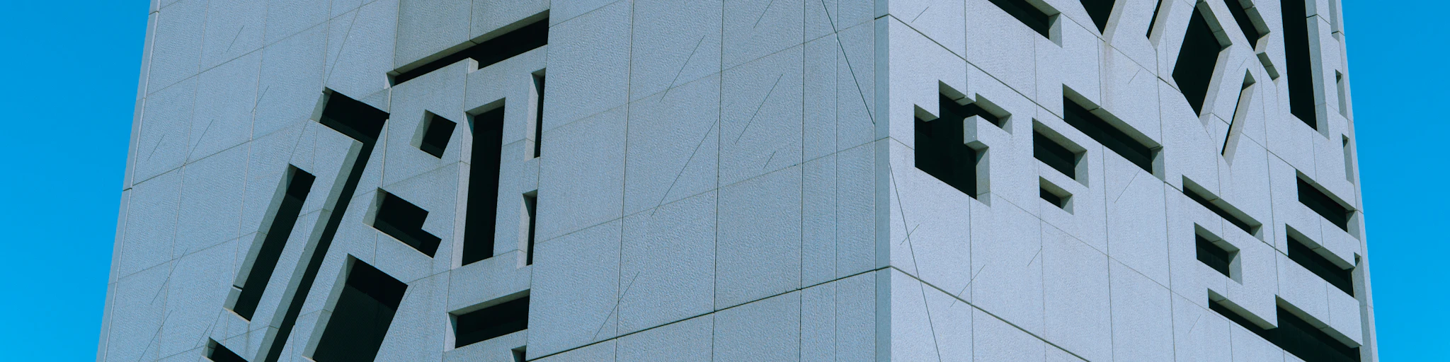 a curved building with a sky in the background