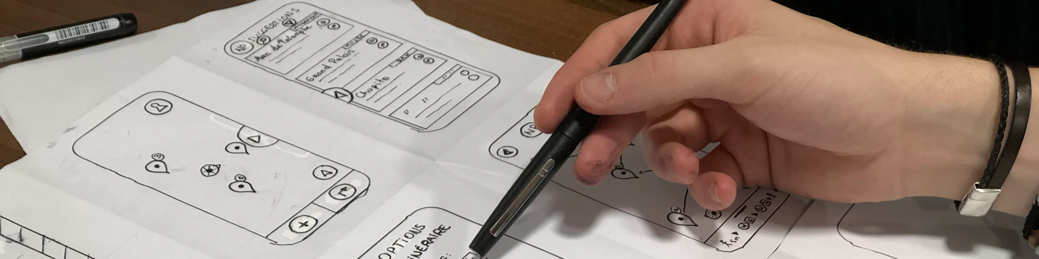 person holding pen near paper