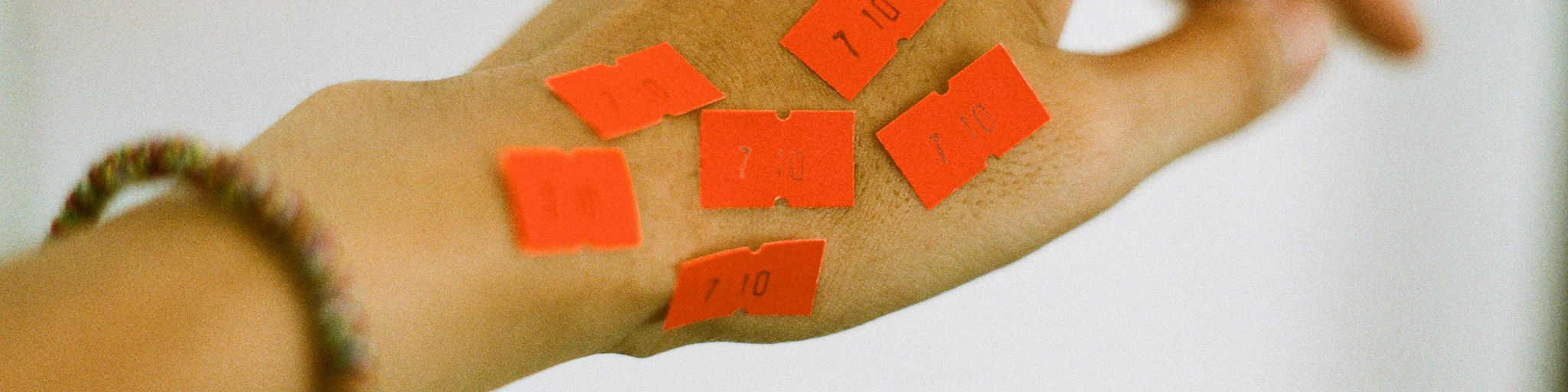 person holding orange and white textile